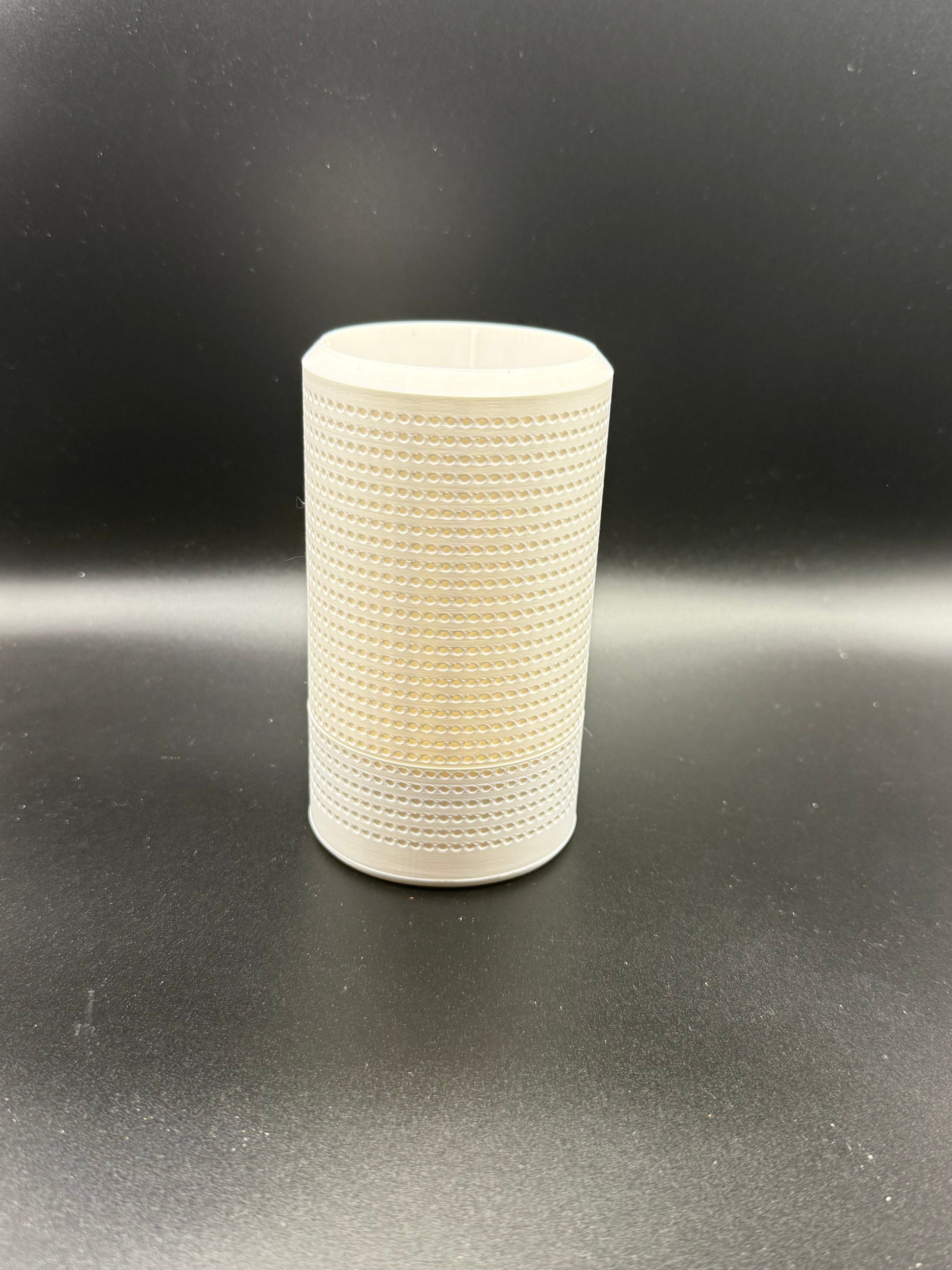 White textured cylindrical object on a black background